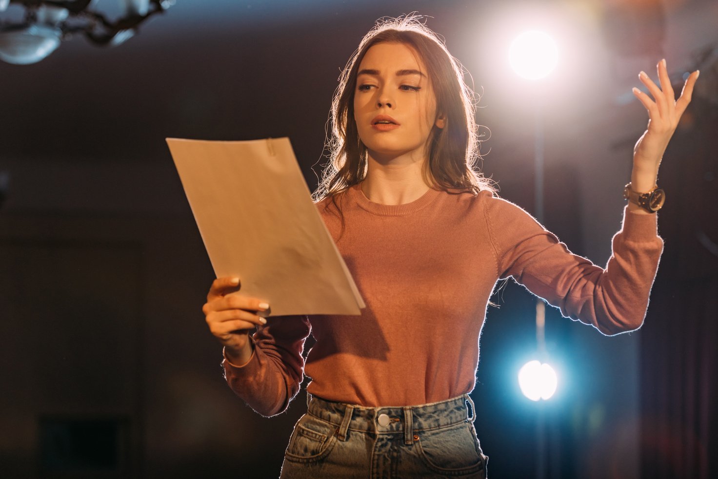 young actress reading scenario on stage in theatre